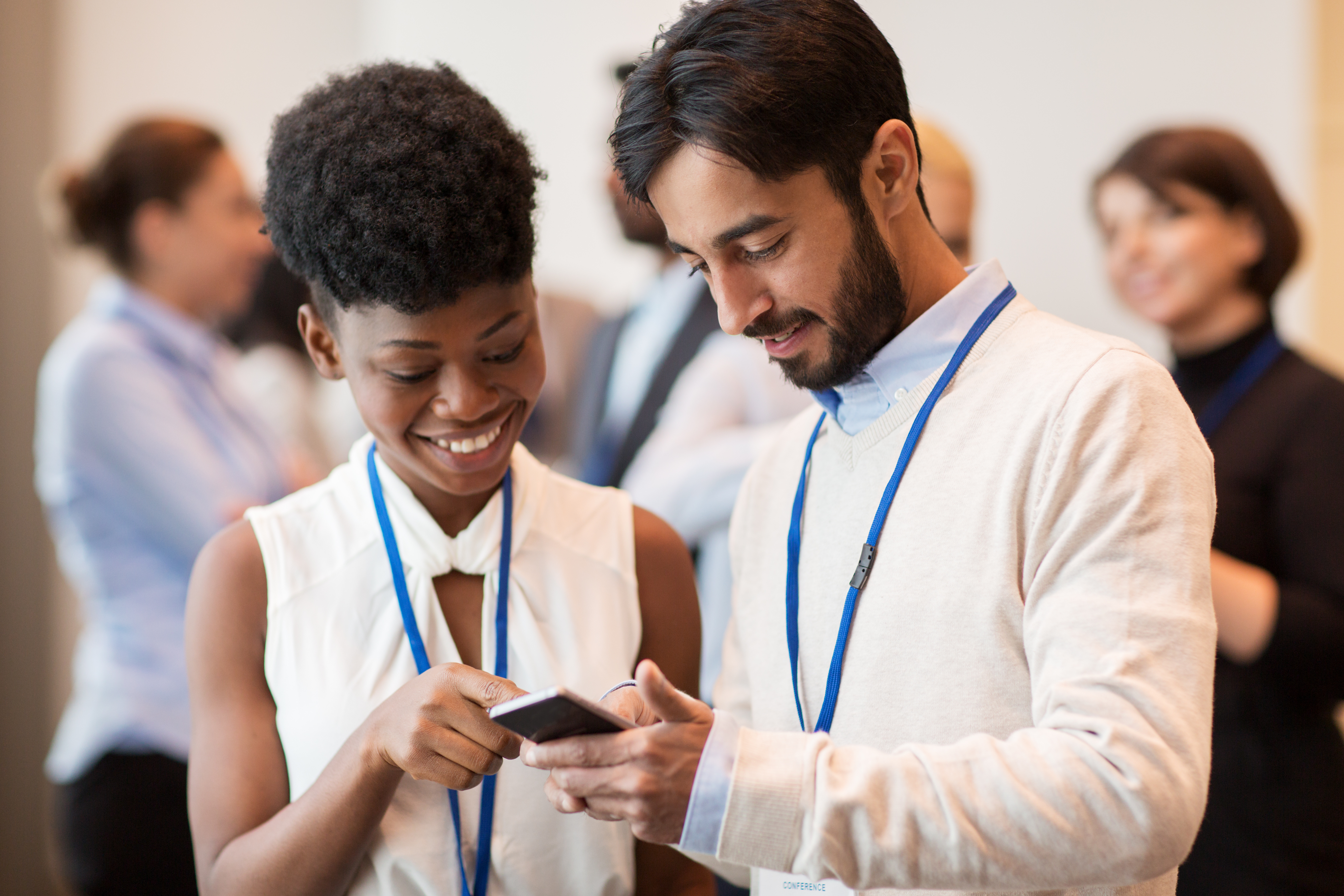 two diverse individuals standing close together interacting at a conference