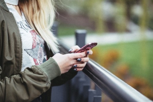 the hands of a young person texting on a phone