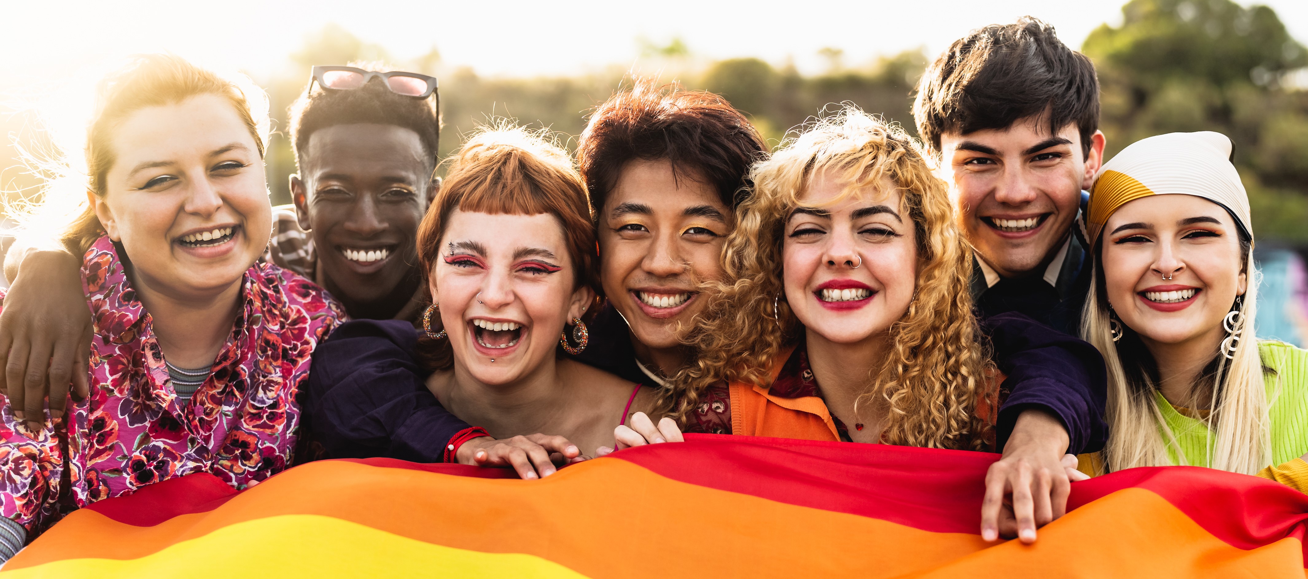 Group of diverse young people holding a rainbow flag
