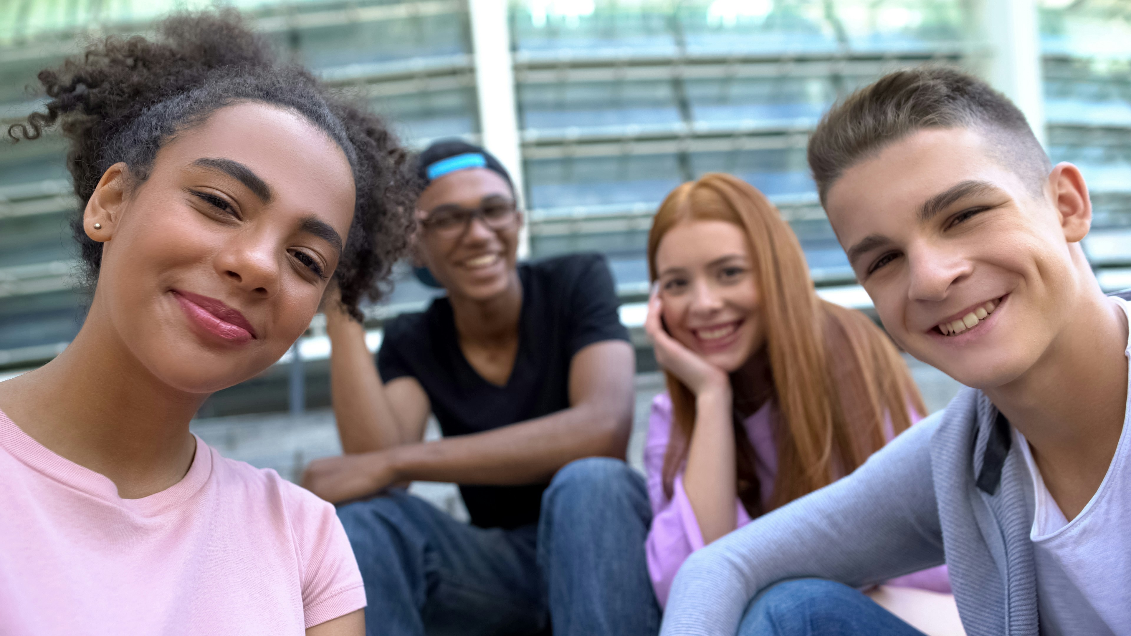4 diverse young adults smiling 